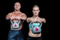 Portrait of muscular man and woman lifting kettlebells Royalty Free Stock Photo
