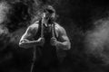 Portrait of muscular sportsman with metal chain. Black background with smoke Royalty Free Stock Photo