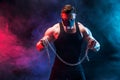 Portrait of muscular sportsman tearing metal chain. Black background with smoke Royalty Free Stock Photo