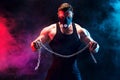 Portrait of muscular sportsman tearing metal chain. Black background with smoke Royalty Free Stock Photo