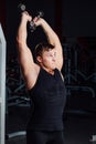 Portrait of a muscular young man lifting weights on gym background. hard training, Royalty Free Stock Photo