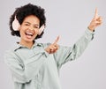 Portrait, music headphones and black woman pointing up in studio isolated on a white background mockup or advertising