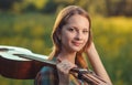 Portrait of a musician young woman in plaid shirt with a acoustic wooden guitar Royalty Free Stock Photo