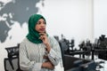 Portrait of muslim black female software developer with green hijab standing at modern open plan startup office Royalty Free Stock Photo