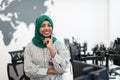 Portrait of muslim black female software developer with green hijab standing at modern open plan startup office Royalty Free Stock Photo