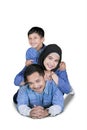 Happy Muslim family lying together on studio Royalty Free Stock Photo