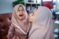 muslim Mother with hijab scarf comforting her crying little girl