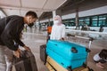 muslim woman and husband carrying a lugage in the airport