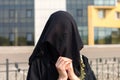 Portrait of a Muslim woman in national clothes covering her face