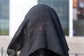 Portrait of a Muslim woman in national clothes covering her face in a European city