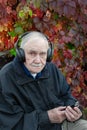 Portrait of a mustachioed Mature man with an attentive and serious face in headphones. An old man is relaxing and listening to Royalty Free Stock Photo