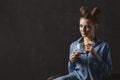 Portrait of mysterious girl with bun hairstyle and evening makeup. Copy space. Woman with cup of coffee,black background Royalty Free Stock Photo