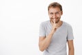 Portrait of mysterious happy and energized handsome man with bristle in glasses and gray t-shirt smiling with enthusiasm