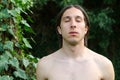 Portrait of naked man with closed eyes standing in forest Royalty Free Stock Photo