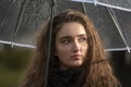 Portrait of natural beauty girl. Beautiful young woman with brown hair dreaming under umbrella. Sadness stare Royalty Free Stock Photo