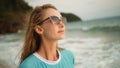 Natural beauty woman walking and relax on beach. Warm golden sunset. Woman with birthmark in blue swimsuit and