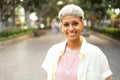 Portrait of natural millenial woman with short blonde hairstyle wearing silver jewelry, earrings and necklace, smiling and looking Royalty Free Stock Photo