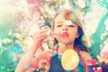 Portrait, nature and kid blowing bubbles at park, relax and girl having fun outdoor. Toy, garden and face of child with Royalty Free Stock Photo