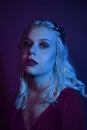 Portrait in neon of a woman in a silver crown with chains. A girl as a princess, queen, princess. Fashion shooting a portrait in Royalty Free Stock Photo