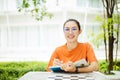 Portrait of nerd Asian woman girl smart teen happy smiling with glasses at green park outdoor in university campus with copyspace