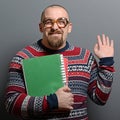 Portrait of a nerd holding book with retro glasses against gray background Royalty Free Stock Photo
