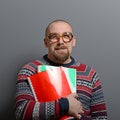 Portrait of a nerd holding book with retro glasses against gray background Royalty Free Stock Photo