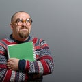 Portrait of a nerd holding book with retro glasses against gray background Royalty Free Stock Photo