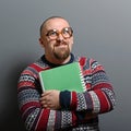 Portrait of a nerd holding book with retro glasses against gray background Royalty Free Stock Photo