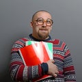 Portrait of a nerd holding book with retro glasses against gray background Royalty Free Stock Photo