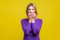 Portrait of nervous anxious woman biting her nails. indoor studio shot isolated on yellow background