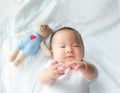 Portrait of a newborn Asian baby boy on the bed , Charming Fat baby 5 month old lies in bed and the doll ,enjoy and happy,soft and Royalty Free Stock Photo