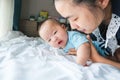 Portrait of a newborn Asian baby boy on the bed , Charming Fat baby 5 month old lies in bed and the doll ,enjoy and happy,soft and Royalty Free Stock Photo