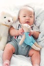 Portrait of a newborn Asian baby boy on the bed with a doll , Charming Royalty Free Stock Photo