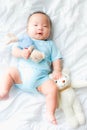 Portrait of a newborn Asian baby boy on the bed with a doll , Charming Royalty Free Stock Photo