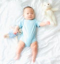 Portrait of a newborn Asian baby boy on the bed with a doll , Charming Royalty Free Stock Photo