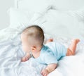Portrait of a newborn Asian cute baby boy wore blue Infant bodysuit crawling on the bed , Charming Fat baby 5 month old enjoy and Royalty Free Stock Photo