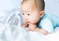 Portrait of a newborn Asian cute baby boy wore blue Infant bodysuit crawling on the bed , Charming Fat baby 5 month old enjoy and Royalty Free Stock Photo