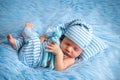 Portrait of a newborn baby 0-14 days old on a blue fur background, a newborn`s dream Royalty Free Stock Photo