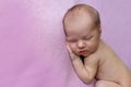 Portrait of a newborn baby girl sleeping on a pink blanket background, place for text, healthy baby sleep Royalty Free Stock Photo