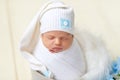 Portrait of a newborn baby girl two weeks sweetly sleeping in a diaper cocoon in a cap Royalty Free Stock Photo