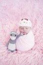 Portrait of newborn baby girl wrapped in pink wrap with knitted woolen crown headband. Infant on furry fluffy background Royalty Free Stock Photo