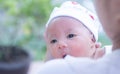 Portrait of a newborn baby infant hold close by mother in the garden, close up. Family