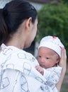 Portrait of a newborn baby infant hold close by mother in the garden, close up. Family