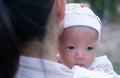 Portrait of a newborn baby infant hold close by mother in the garden, close up. Family