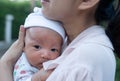 Portrait of a newborn baby infant hold close by mother in the garden, close up. Family