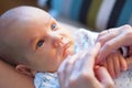 Portrait of newborn baby lying on back and looking up at mother. Mothers hands holding babies hands. Love and tenderness Royalty Free Stock Photo