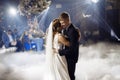 Portrait of newlyweds first wedding dance. Just married couple dancing in darkness. Groom holds bride& x27;s hand dancing Royalty Free Stock Photo