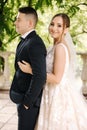 Portrait of newlyweds stand on balcony and dreaming. Handsome groom and beautiful bride on their wedding day Royalty Free Stock Photo