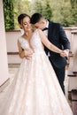 Portrait of newlyweds stand on balcony and dreaming. Handsome groom and beautiful bride on their wedding day Royalty Free Stock Photo