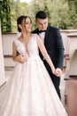 Portrait of newlyweds stand on balcony and dreaming. Handsome groom and beautiful bride on their wedding day Royalty Free Stock Photo